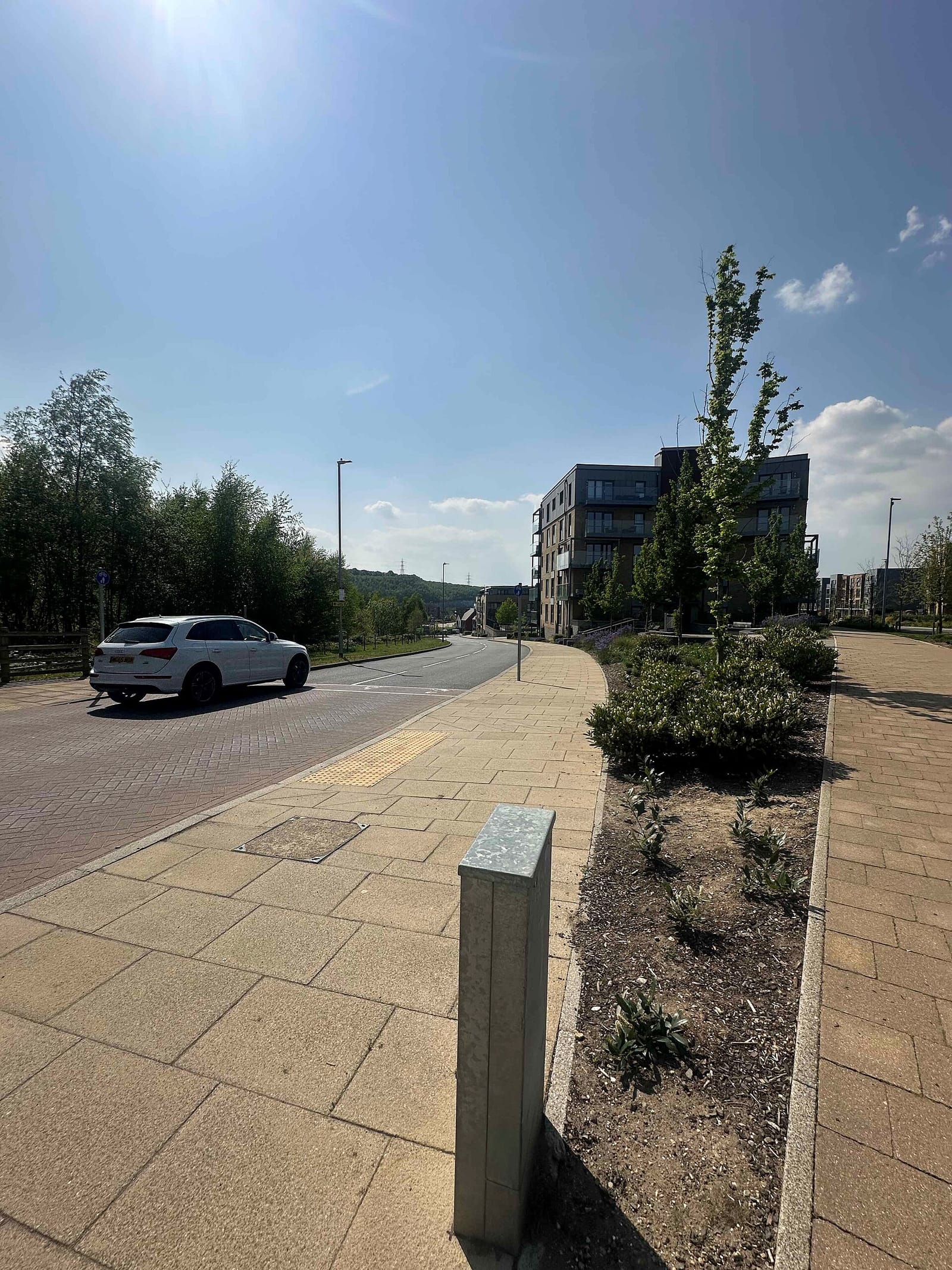New apartment blocks and block-paved pavements on Castle Hill Drive in Ebbsfleet Valley, seen on a sunny day.