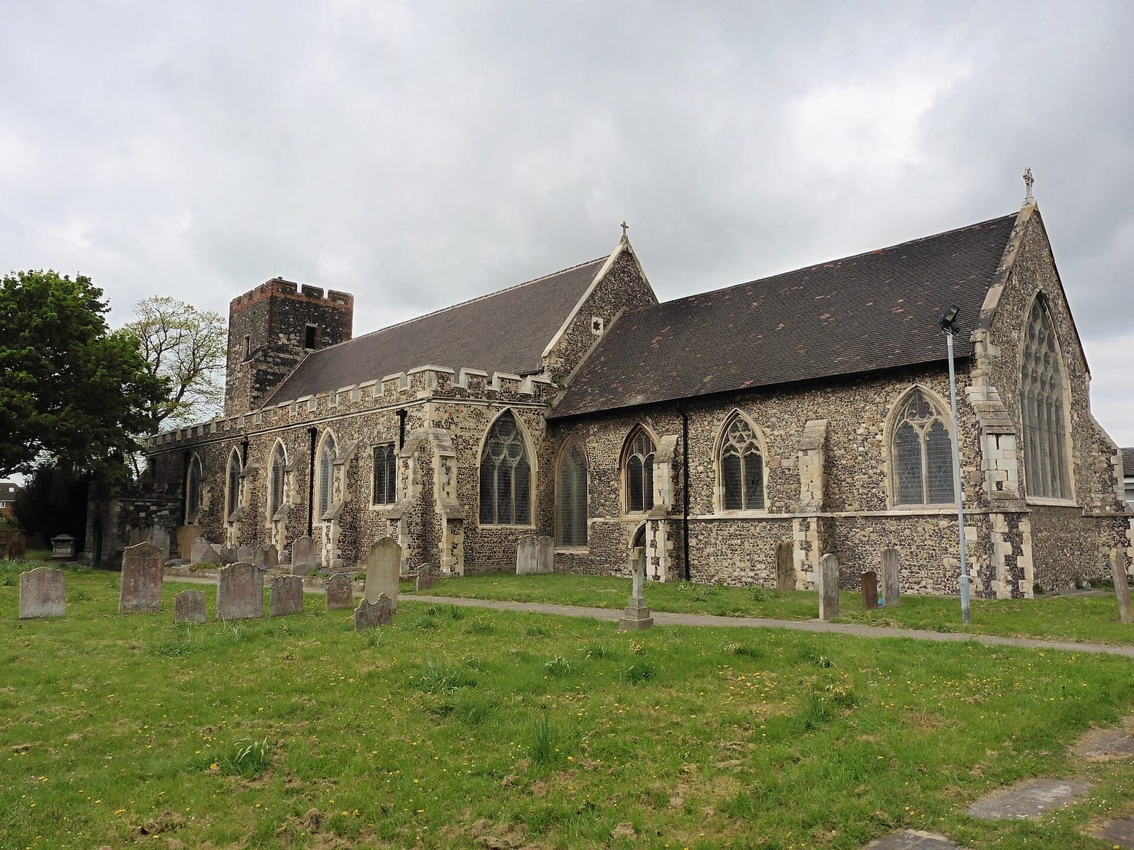 St Botolph's Church in Northfleet, a flint parish church seen across its churchyard.